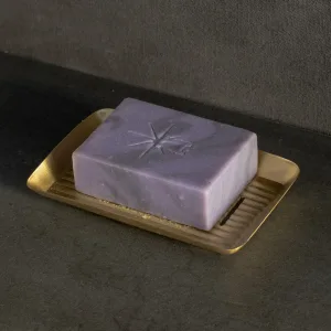Black Altar Mystic Twilight soap resting in a gold metal dish on a granite countertop.