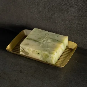 Black Altar Wild Conjuring soap bar resting in a gold metal dish on a granite countertop.