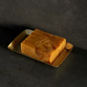 Black Altar Ritual Ember Bar resting in a gold metal dish on a granite countertop.