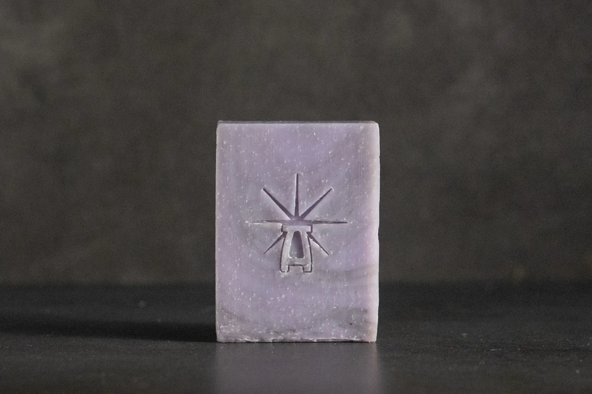 Studio shot of Black Altar Mystic Twilight soap—dusty lavender bar with star-altar logo on dark backdrop