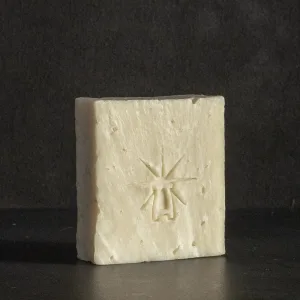 Studio shot of Black Altar Earth Salt soap—creamy off-white bar with subtle salt texture and star-altar logo.