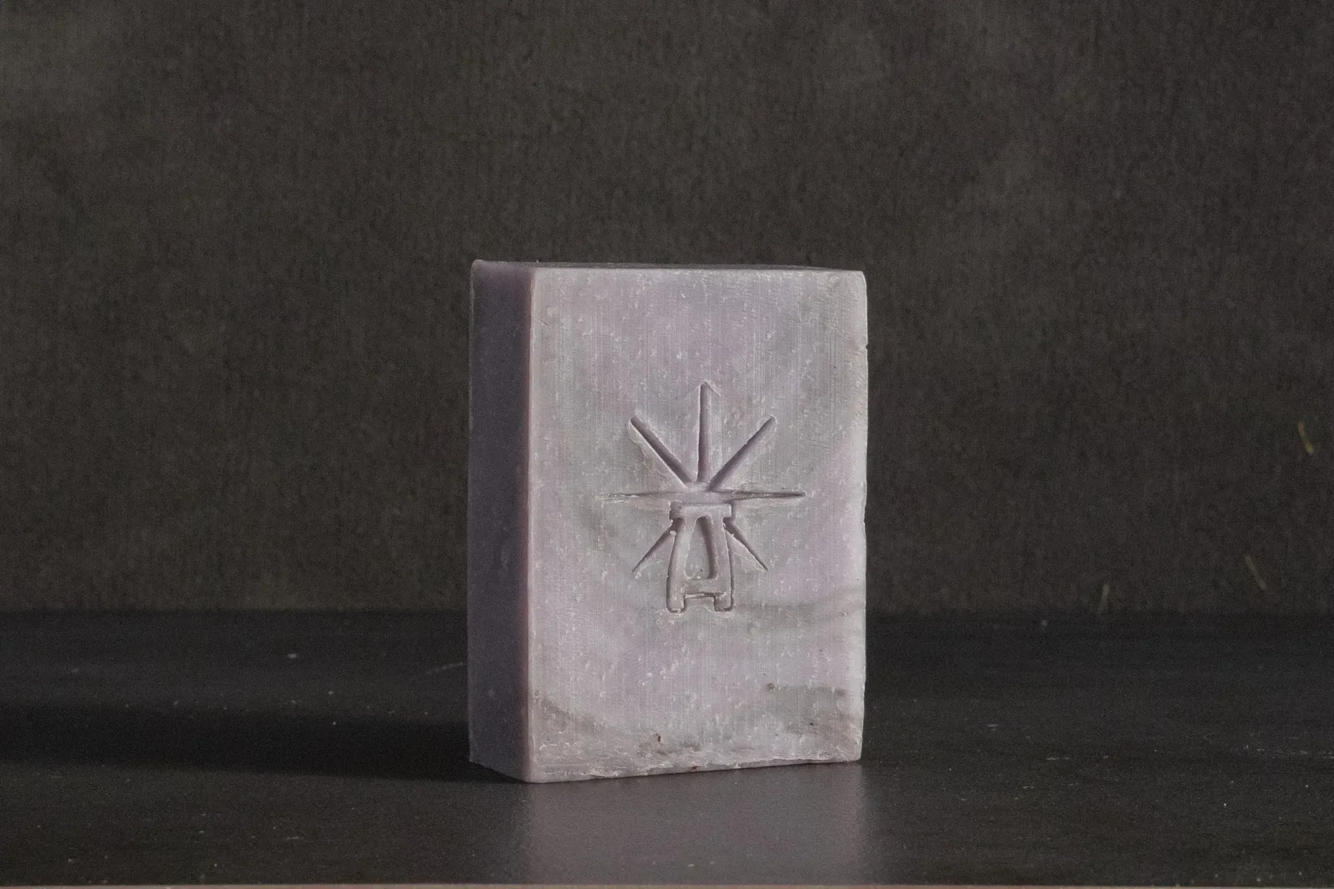 Studio shot of Black Altar Mystic Twilight soap—dusty lavender bar with star-altar logo on dark backdrop