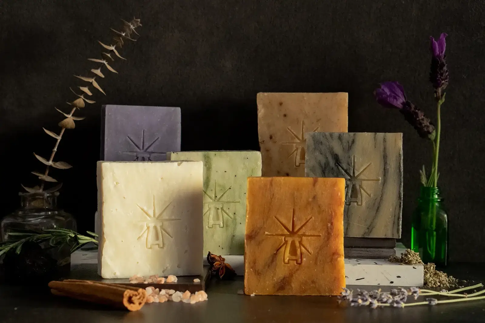 The altar's grace kit features each bar standing on mini altars closely in a dark moody scene surrounded by ingredients.