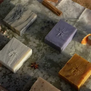 The altar's grace kit features each bar lying flat on beautiful hand cut fabrics in a moody scene surrounded by ingredients.