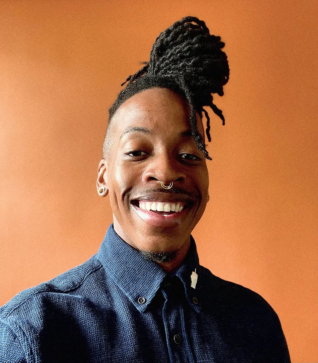 Phillip smiling against an orange background