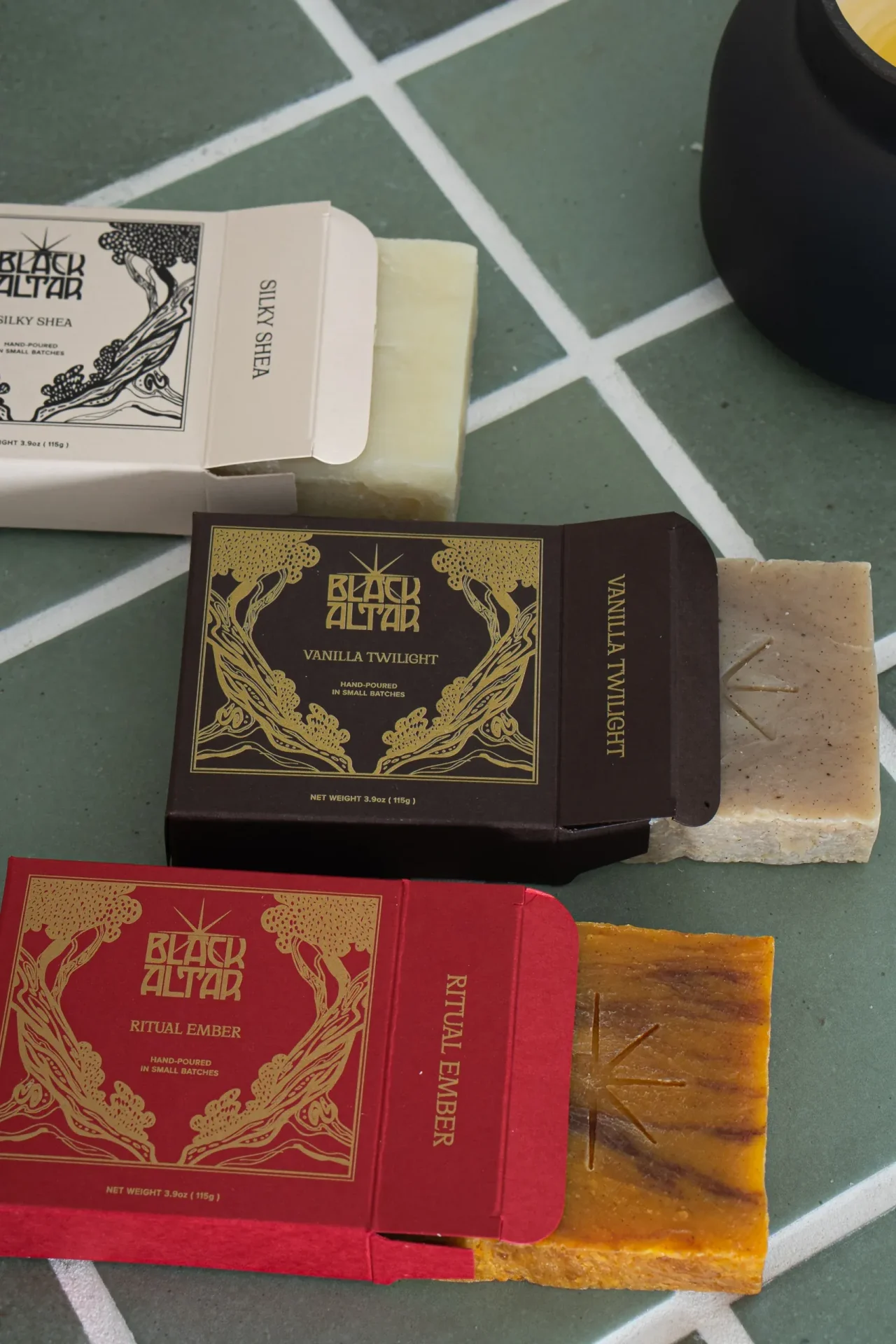 Black Altar boxed soaps and loose amber bar arranged around a black candle
