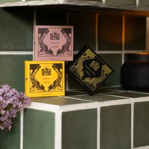 Stacked Black Altar soap boxes in pink, yellow, and black gold packaging