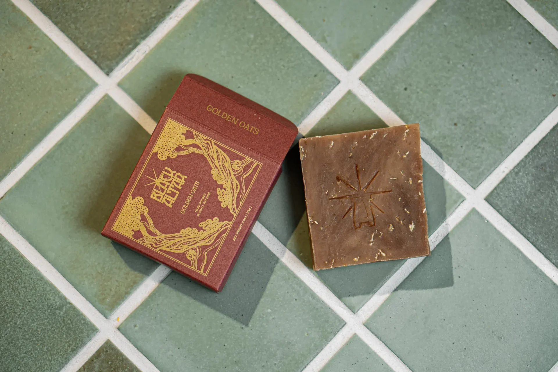 Black Altar red boxed soap with stamped brown natural soap bar on tile