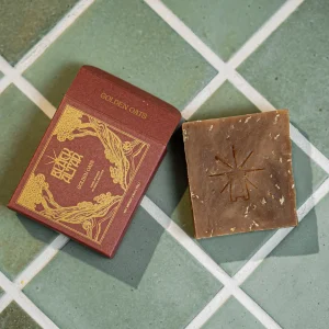 Black Altar red boxed soap with stamped brown natural soap bar on tile