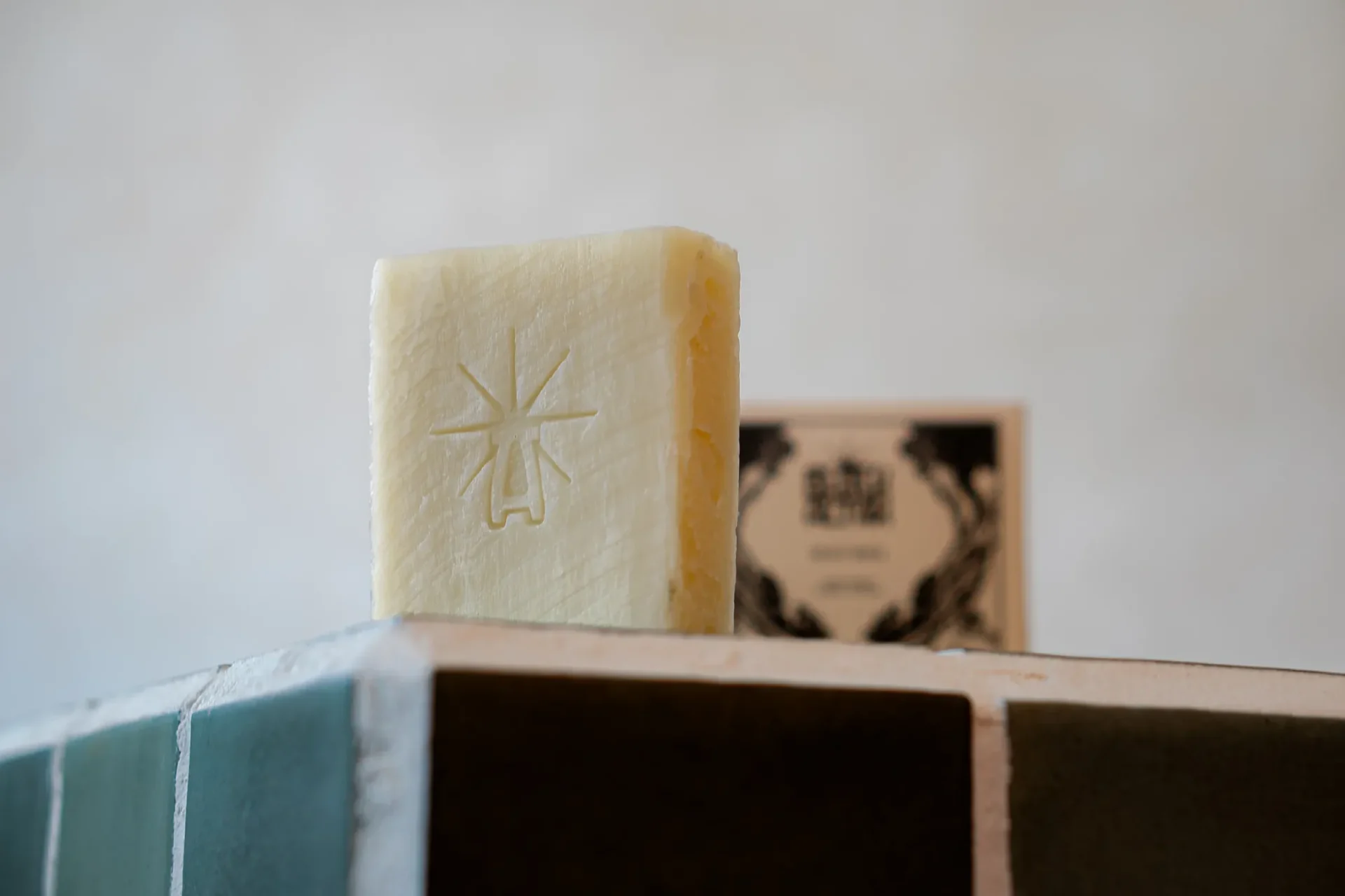 Black Altar plain cream stamped soap bar standing upright on green tile