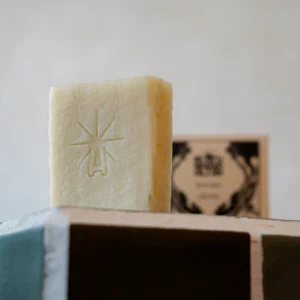 Black Altar plain cream stamped soap bar standing upright on green tile