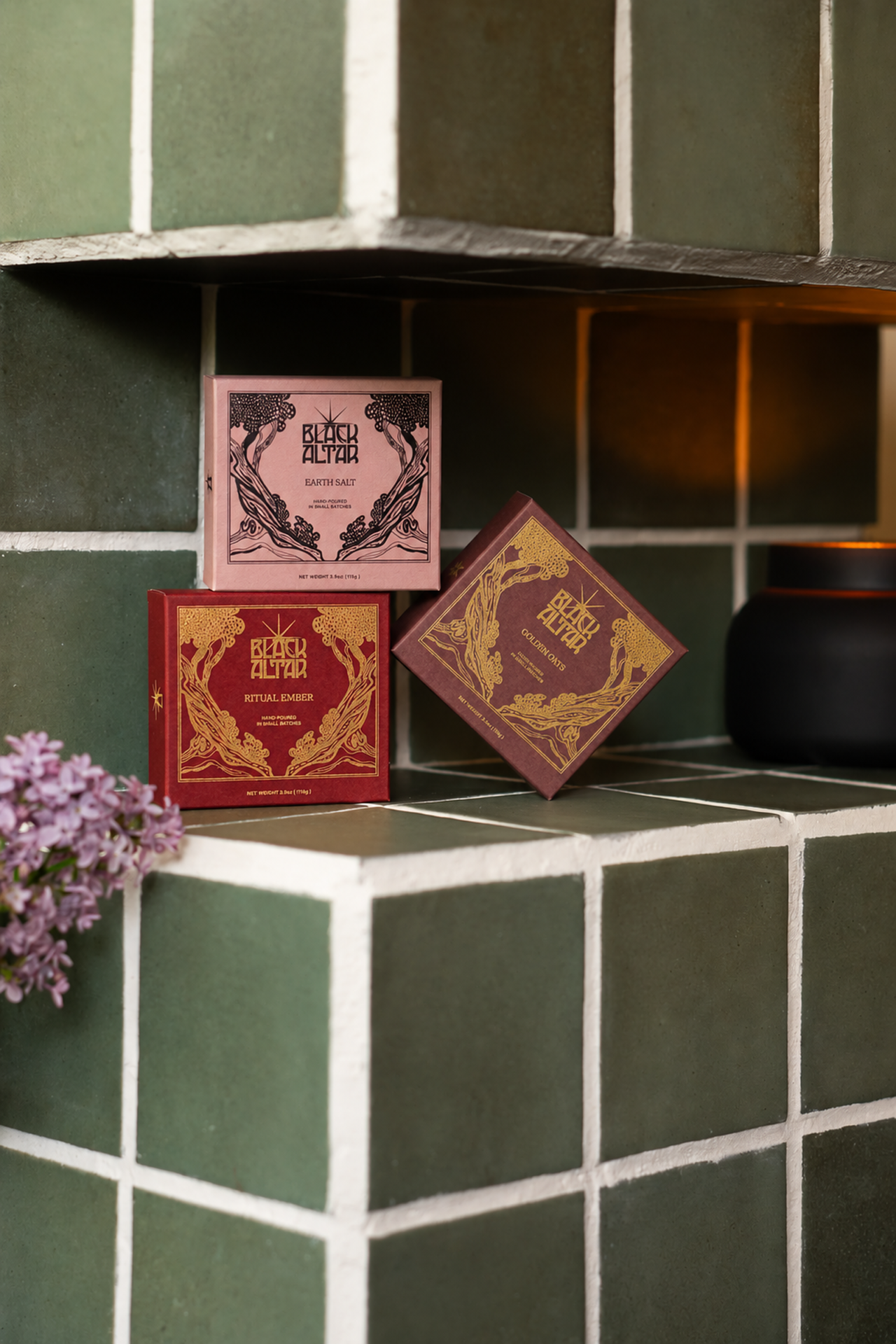 Earth Salt, Ritual Ember and Golden Oat boxes on a green tiled shower shelf