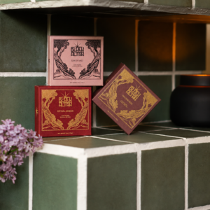 Earth Salt, Ritual Ember and Golden Oat boxes on a green tiled shower shelf